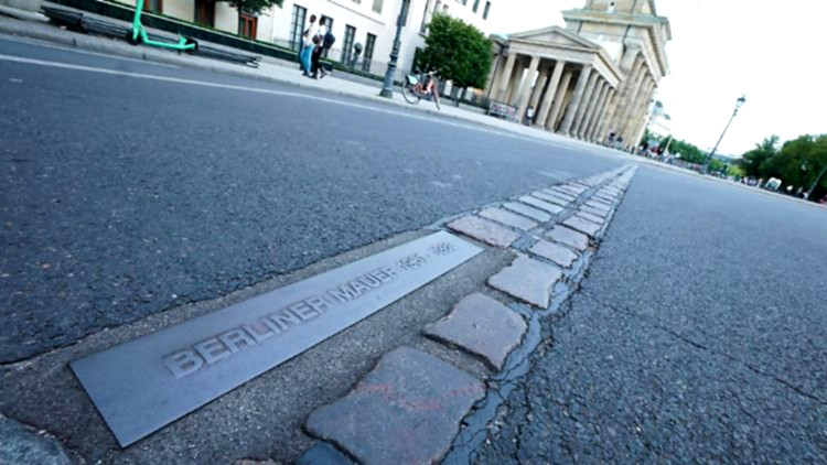 Menschen erinnern an Berliner Mauer.